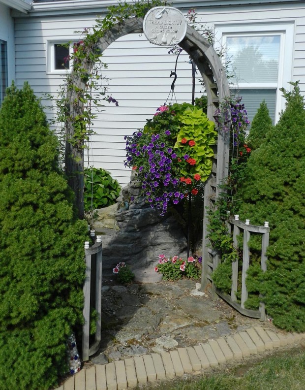Larry made the arbor for this corner garden that sits next to their sunroom where they relax and listen to singing birds playing in the water. There are two ‘Jackmanii' clematis on the arbor, several hostas, and two Alberta spruces for seclusion.