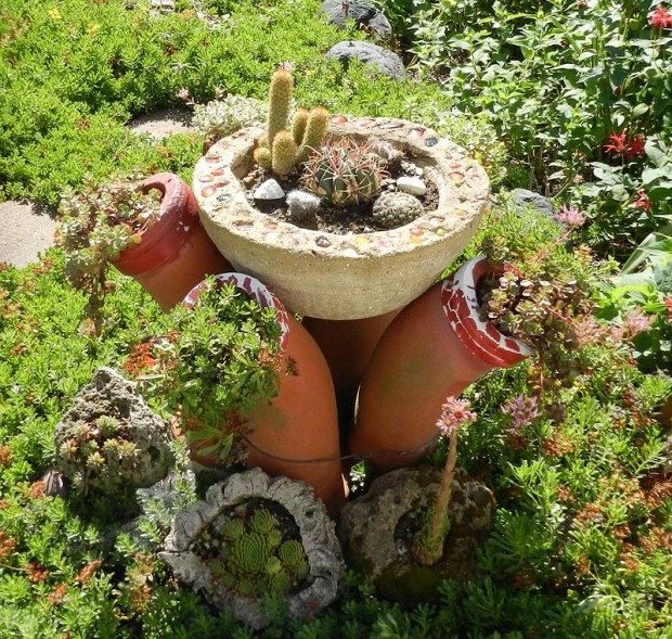Judy collects cacti, even though most are not hardy in Michigan and must be taken inside. The pot of succulents is made of five drain tiles turned upside down and wired together to form a flower shape. The display is crowned by a hypertufa pot made by a fellow Master Gardener.