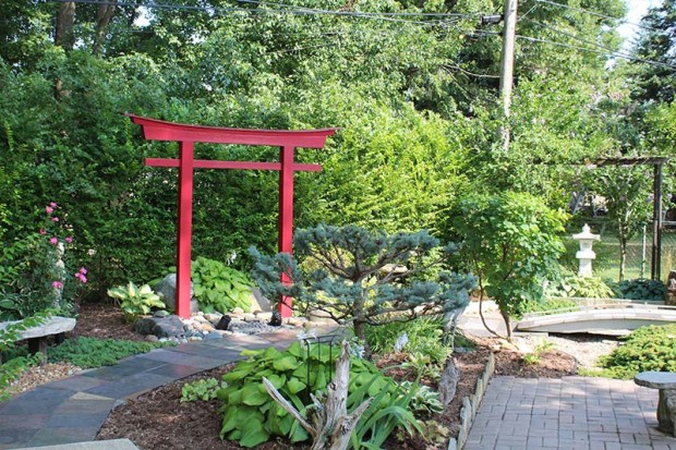 Against a green shrub backdrop, the red torii gate is a striking focal point in the Resch’s Asian-themed garden.